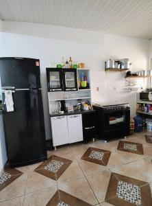 a kitchen with a black refrigerator and a stove at Casa em Mosqueiro com Piscina in Belém