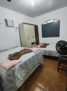 a room with two beds and a chair and a mirror at Casa em Mosqueiro com Piscina in Belém +24 photos