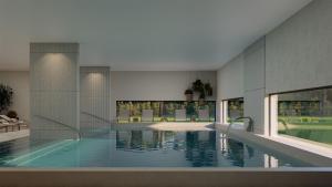 a large swimming pool in a building with water at The Lince Ecorkhotel Évora in Évora