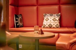 a red couch with a table and pillows at Hotel M'Rode in Lomé