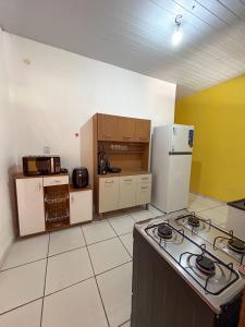 a kitchen with a stove and a refrigerator at Ksa Sodré in Barreirinhas