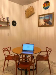 a table with a laptop sitting on top of it at Ksa Sodré in Barreirinhas +4 photos