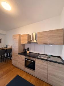 a kitchen with wooden cabinets and a stove top oven at Westwind 2 in Steinfeld