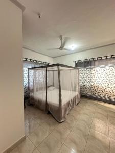 a bedroom with a canopy bed in a room at Diddy & Eddy's apartment in Malindi