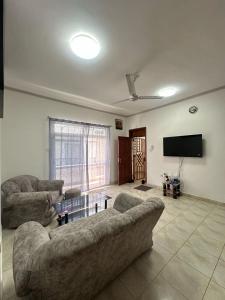 a living room with two couches and a flat screen tv at Diddy & Eddy's apartment in Malindi