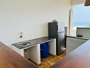 a kitchen with a sink and a refrigerator at Murthy Surf School in Covelong +11 photos