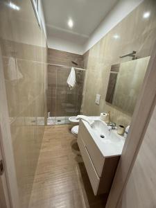 a bathroom with a sink and a shower and a toilet at La Loggia sui Giardini in Mola di Bari