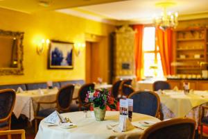 a dining room with tables and chairs with flowers on them at Romantik Hotel Bülow Residenz in Dresden