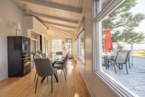 a living room with a table and chairs and a large window at Le Gaspesiana in Sainte-Flavie