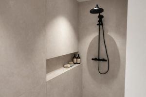 a shower in a bathroom with a wall at Burgschelde 61 in Oudenaarde +2 photos