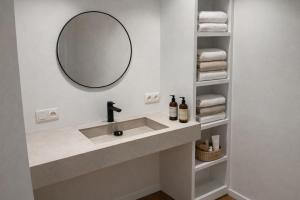 a bathroom with a sink with a mirror and towels at Burgschelde 61 in Oudenaarde