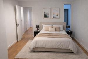 a white bedroom with a large bed with two tables at Burgschelde 61 in Oudenaarde