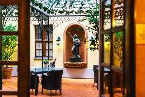a room with a table and a statue of a woman at Romantik Hotel Bülow Residenz in Dresden