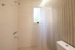 a white bathroom with a shower and a window at Casa Frida vivir sin prisa in Mar de las Pampas +11 photos