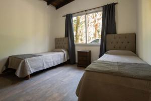 a bedroom with two beds and a window at Casa Frida vivir sin prisa in Mar de las Pampas
