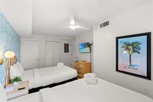 a bedroom with two beds and a picture of a palm tree at Wow! Oceanview 3 bedroom condo! Pool & private balcony in Myrtle Beach +67 photos