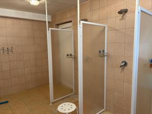 a shower with a glass door in a bathroom at Atpūtas komplekss Cerības in Dauguļi +46 photos