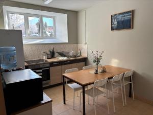 a kitchen with a table and chairs in a kitchen at Atpūtas komplekss Cerības in Dauguļi