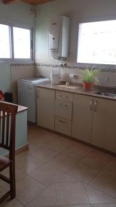 a kitchen with white cabinets and a sink and a window at Dpto amueblado con cochera descubierta in Río Tercero