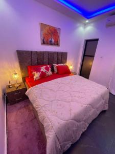 a bedroom with a large bed with red pillows at AmkGroup in Dakar