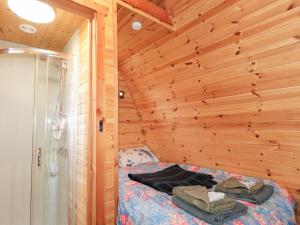 a bedroom with wooden walls and a bed in a room at Pod 1 in Belladrum