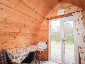 a dining room with a table and a window at Pod 1 in Belladrum