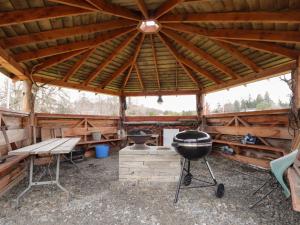 a large wooden cabin with a grill and a picnic table at Pod 1 in Belladrum