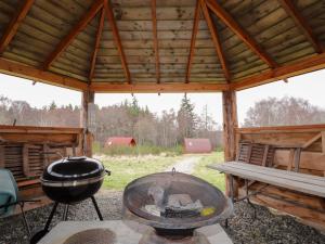 a large wooden pavilion with a bbq grill and a grill at Pod 1 in Belladrum