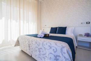a bedroom with a bed with a stuffed animal on it at Hotel Baia Azzurra in Taormina