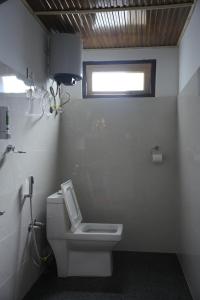 a bathroom with a white toilet and a window at Amarvi Hotel & Resort in Kalimpong