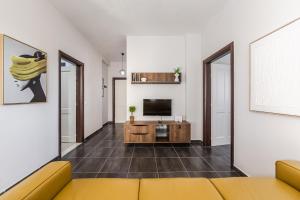 a living room with a couch and a television at The Seabreeze Apartment by PikHost in Lalzit Bay