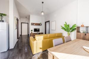 a living room with a yellow couch and a table at The Seabreeze Apartment by PikHost in Lalzit Bay