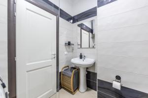 a white bathroom with a sink and a mirror at The Seabreeze Apartment by PikHost in Lalzit Bay +22 photos