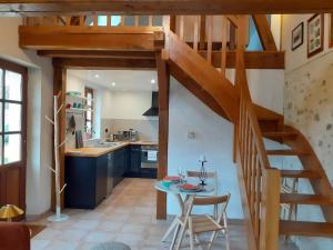 a kitchen with a wooden staircase and a table at Gites au fil des châteaux de la Loire in Saint-Georges-sur-Cher