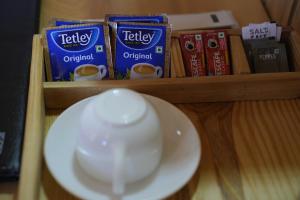 a shelf with a bowl of teazos and books on it at Amarvi Hotel & Resort in Kalimpong