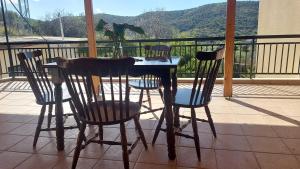 a table and chairs on a balcony with a dinosaur statue at FAVIEROS-The secret Garden in Mesochórion