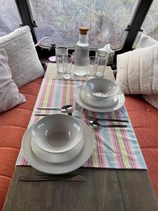 a table with white plates and glasses on a table at Kerry Country House in Kilteean