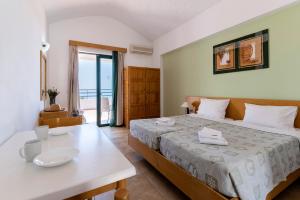 a bedroom with a bed and a table with a white table sidx sidx at Stella Hotel in Pefki +133 photos