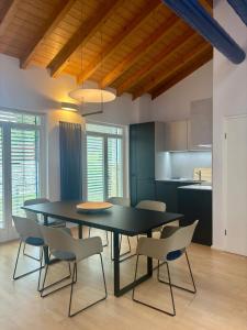 a dining room with a black table and chairs at D&D Guesthouse in Angelbachtal