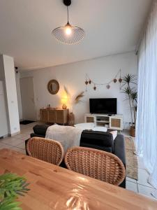 a living room with a couch and a tv at Le bohème Chauraisien in Chauray