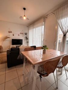 a living room with a table and a couch at Le bohème Chauraisien in Chauray