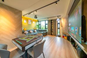 a living room with a couch and a table and chairs at 閒晃趣-包棟民宿-依訂房人數提供房間數 in Ch'i-wu-lao