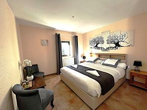 a bedroom with a large bed and a chair at Chambres d'hôtes les Etoiles in Mareugheol