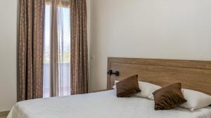 a bedroom with a bed with two pillows and a window at Kalispera Residence in Scalea +35 photos