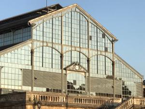 a large glass building with a clock on it at Le bohème Chauraisien in Chauray