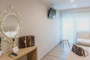 a living room with a mirror and a table at Ammos Beach Seaside Luxury Suites Hotel in Olympic Beach