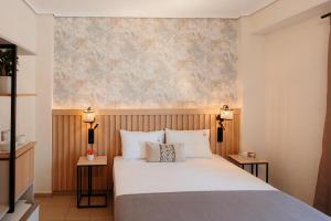 a bedroom with a bed with two night stands and two lamps at Aqua Beachfront Elegant Hotel in Olympic Beach