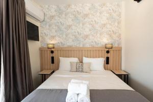 a bedroom with a bed with two pillows on it at Aqua Beachfront Elegant Hotel in Olympic Beach