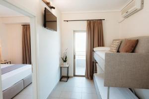 a bedroom with a bed and a couch and a window at Aqua Beachfront Elegant Hotel in Olympic Beach