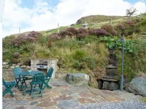 a table and chairs sitting on a stone patio at Hollyglen House in Common Bridge